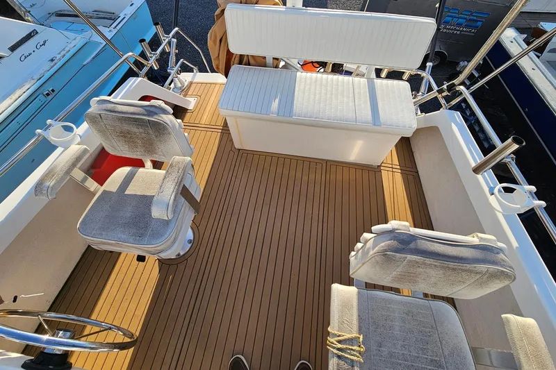 Slide: The Image of 2010 Eastern Casco Bay 35 boat interior with cushioned seating and wooden deck. - 11