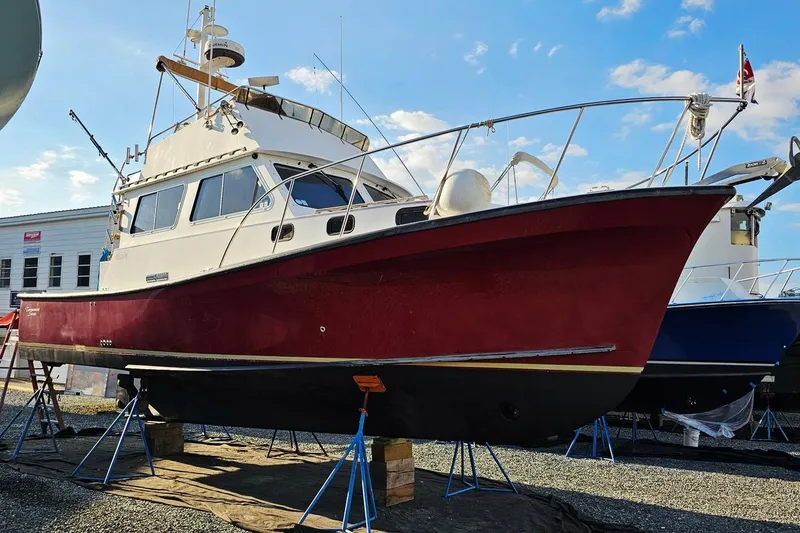 Slide: The Image of 2010 Eastern Casco Bay 35 boat on stands, red hull, marina background. - 2
