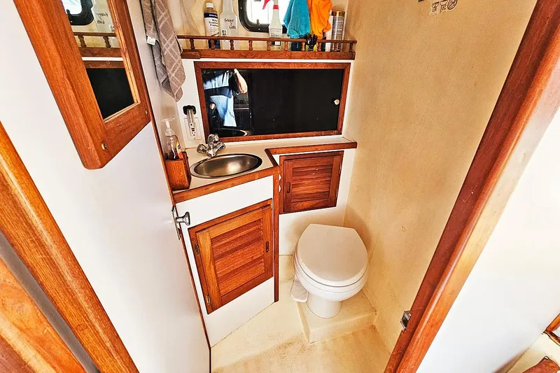 Slide: The Image of 2010 Eastern Casco Bay 35 boat bathroom with wooden cabinets, sink, and toilet. - 22