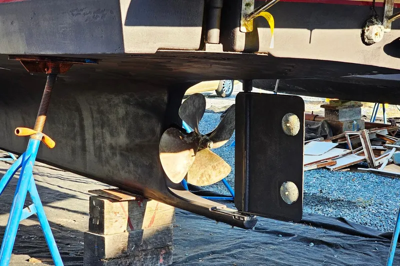 Slide: The Image of 2010 Eastern Casco Bay 35 boat propeller and rudder on stands. - 3