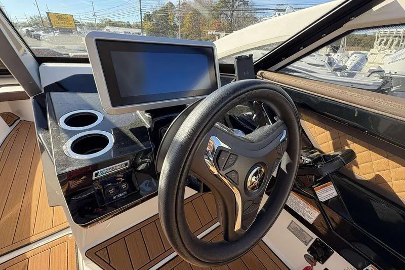 Slide: The Image of 2024 Yamaha 275 SD boat dashboard with steering wheel and touchscreen display. - 10