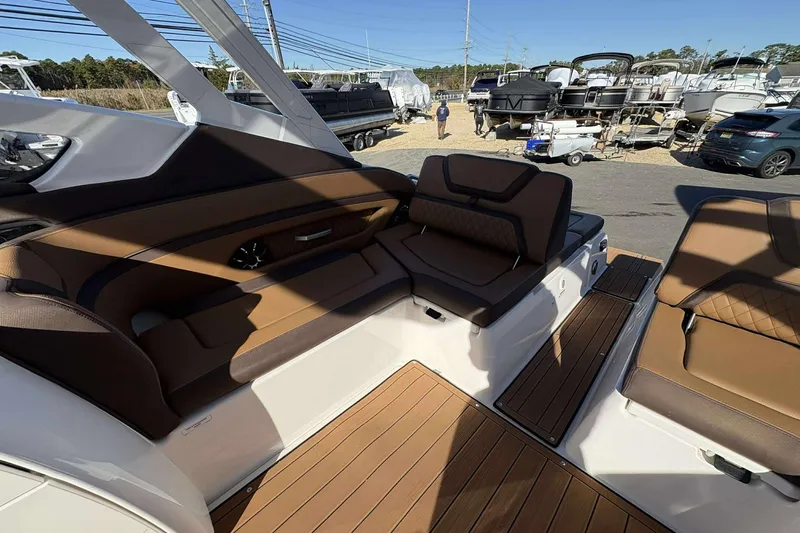 Slide: The Image of 2024 Yamaha 275 SD boat interior with brown seating and wood flooring. - 16