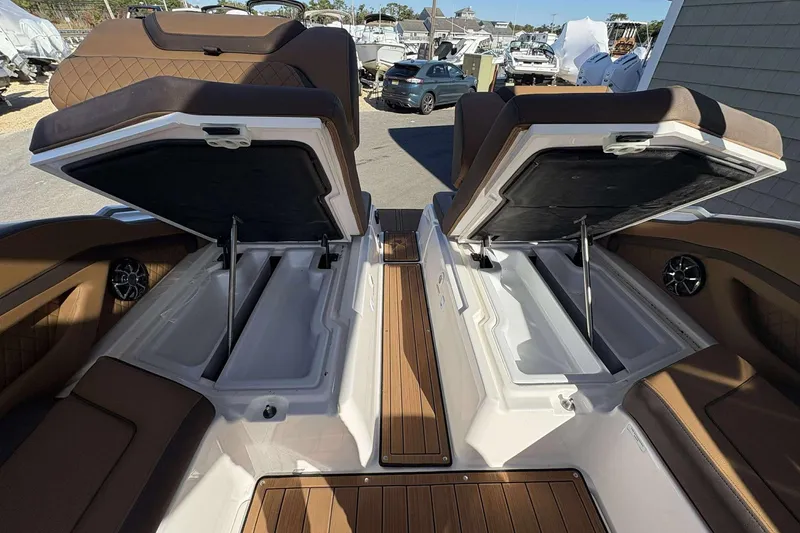 Slide: The Image of 2024 Yamaha 275 SD boat interior with open storage compartments and luxurious seating. - 18