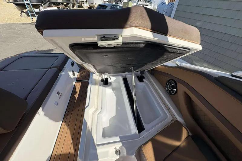 Slide: The Image of 2024 Yamaha 275 SD boat interior storage compartment with open seat and speaker. - 19