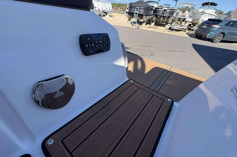 Slide: The Image of 2024 Yamaha 275 SD boat deck with control panel and wood finish. - 20