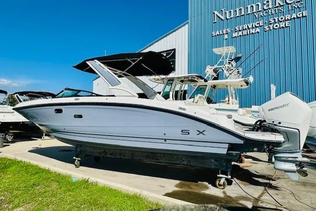 The Image of 2025 Sea Ray SDX 290 Outboard boat displayed at a marina, featuring sleek design and Mercury engines. - 0