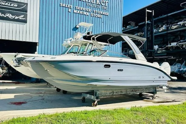 Slide: The Image of 2025 Sea Ray SDX 290 Outboard boat displayed at a marina storage facility. - 1