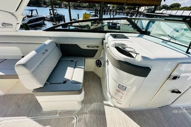 Slide: The Image of 2025 Sea Ray SDX 290 Outboard interior with seating and helm, dockside view. - 13