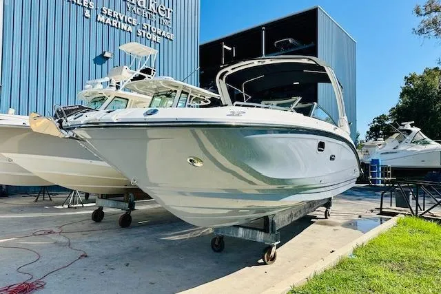 Slide: The Image of 2025 Sea Ray SDX 290 Outboard boat displayed at marina storage facility. - 2