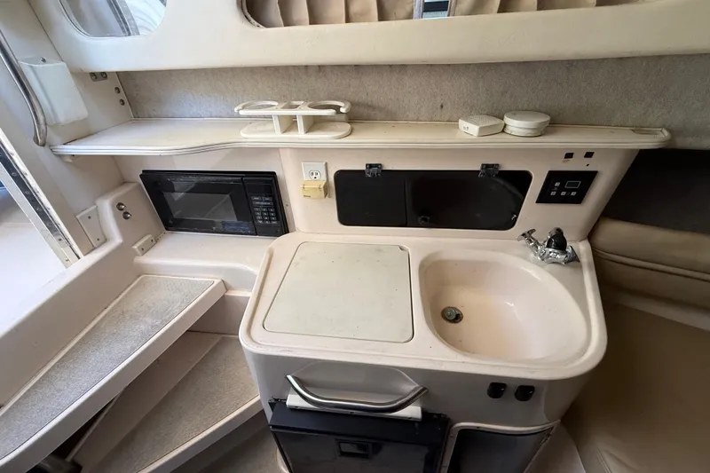 Slide: The Image of 1998 Grady-White Marlin 300 boat interior with kitchenette, sink, and microwave. - 16