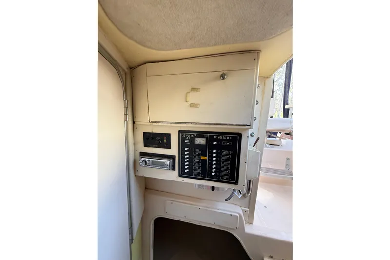 Slide: The Image of 1998 Grady-White Marlin 300 boat interior with control panel and storage compartment. - 18