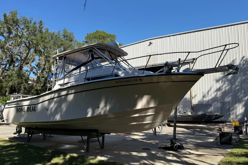 Slide: The Image of 1998 Grady-White Marlin 300 boat on display outdoors near a large building. - 4