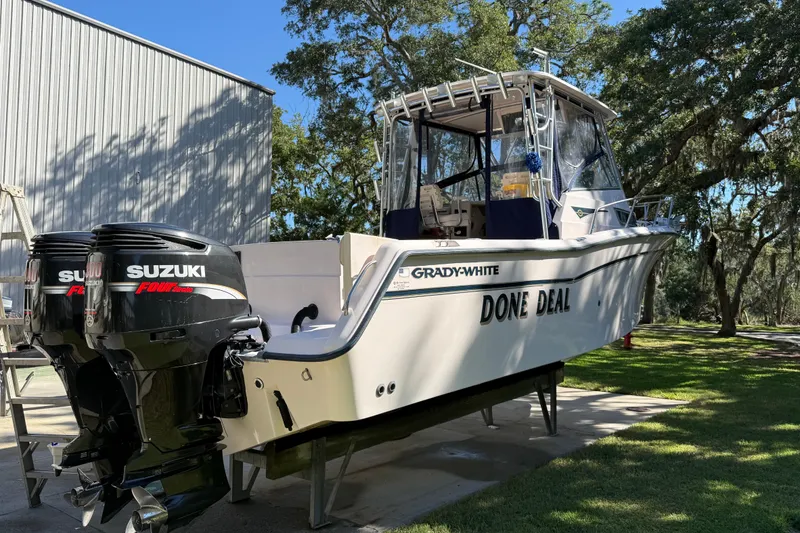 Slide: The Image of 1998 Grady-White Marlin 300 boat with twin Suzuki engines on display outdoors. - 5