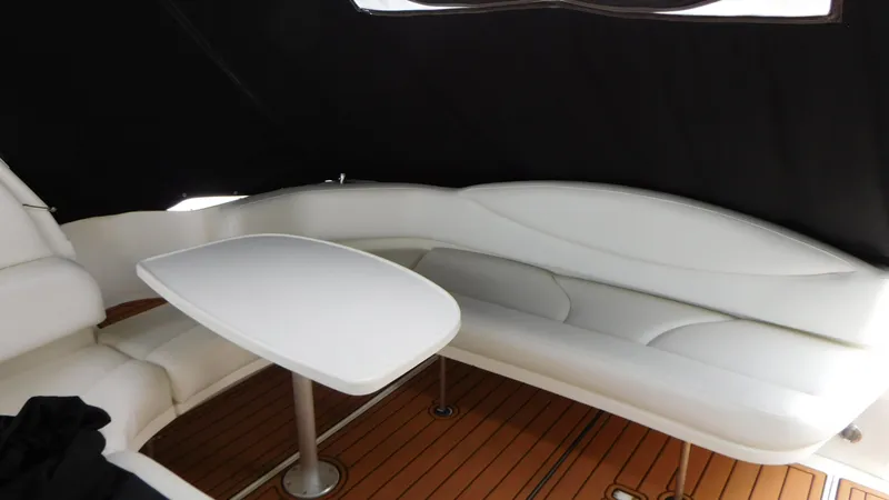 Slide: The Image of Interior of 2002 Sea Ray 380 Sundancer with white seating and wooden flooring. - 10