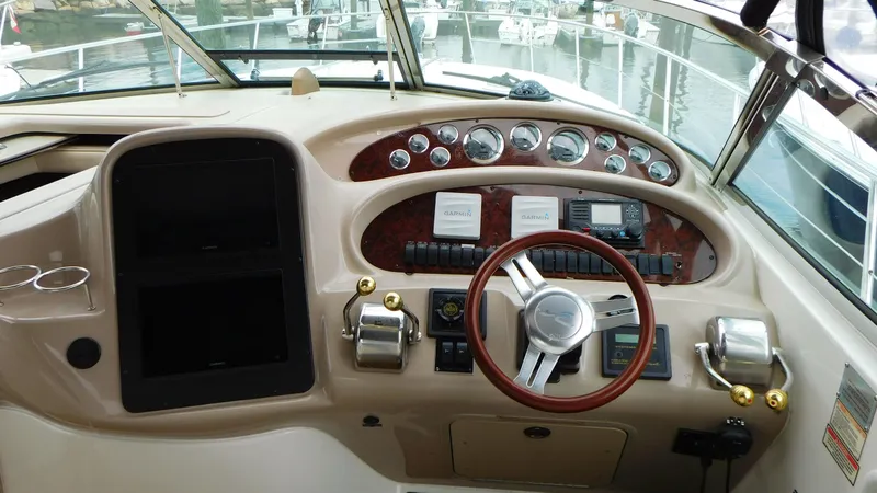 Slide: The Image of Helm of 2002 Sea Ray 380 Sundancer with gauges and controls, docked at marina. - 12