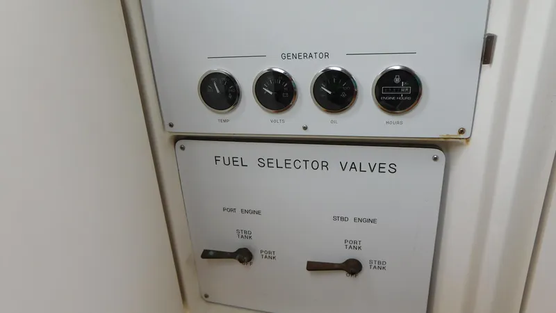 Slide: The Image of Control panel of a 2002 Sea Ray 380 Sundancer with fuel selector valves and generator gauges. - 27