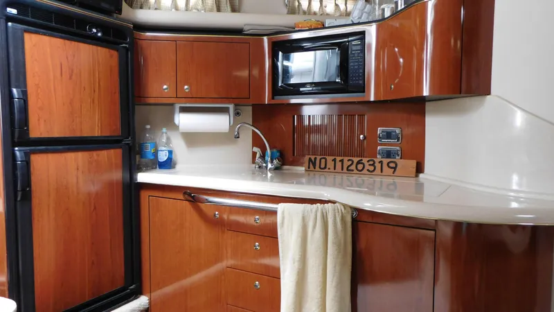 Slide: The Image of 2002 Sea Ray 380 Sundancer yacht kitchen with wood cabinetry and modern appliances. - 35