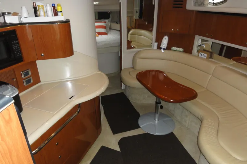 Slide: The Image of 2002 Sea Ray 380 Sundancer interior with kitchenette, curved seating, and table. - 52