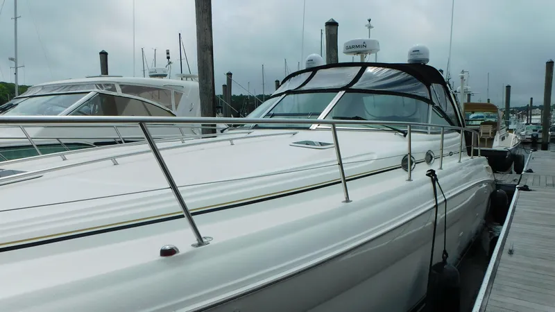 Slide: The Image of 2002 Sea Ray 380 Sundancer docked at marina, showcasing sleek design and spacious deck. - 6