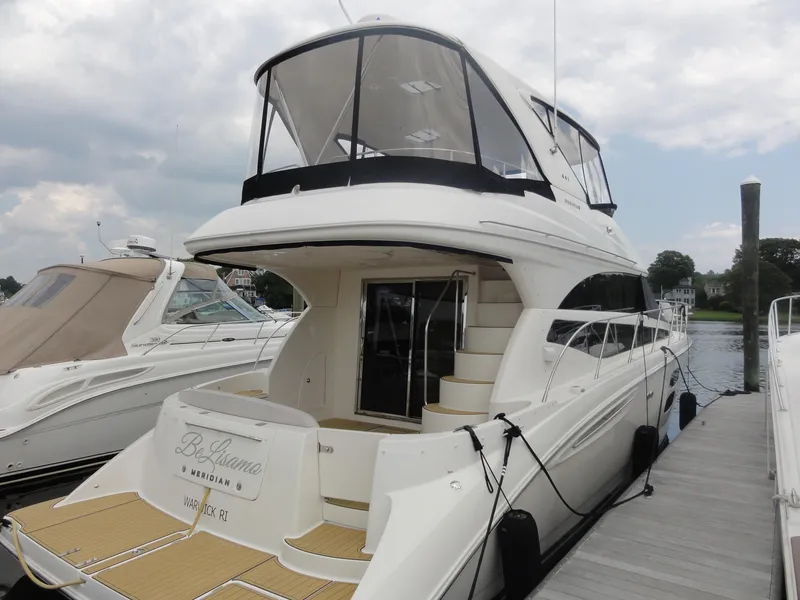 Slide: The Image of 2009 Meridian 441 Sedan yacht docked at marina, featuring sleek design and spacious deck. - 6