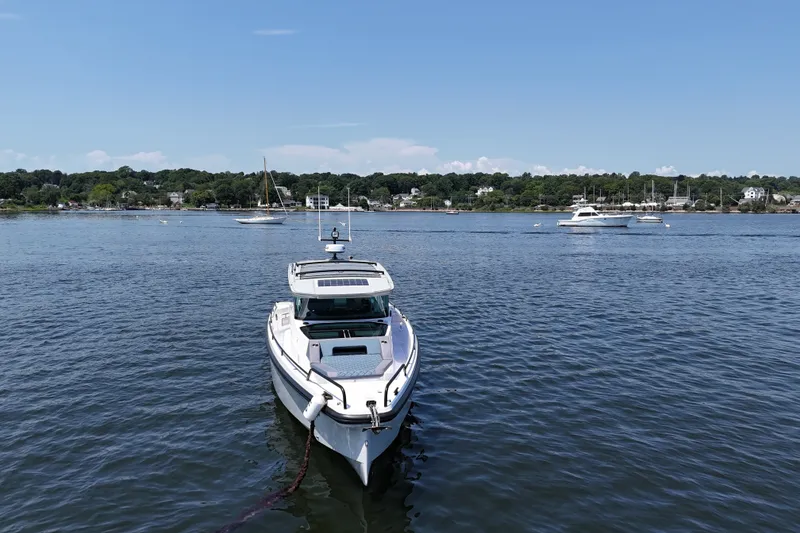 Slide: The Image of 2026 Axopar 37 XC Cross Cabin boat on calm water with scenic shoreline background. - 1