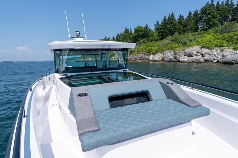 Slide: The Image of Axopar 37 Aft Cabin 2026 boat by the water with coastal view. - 21