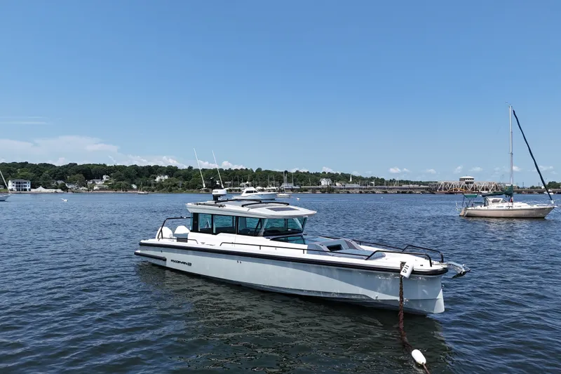 Slide: The Image of 2026 Axopar 37 XC Cross Cabin boat on calm water under clear blue sky. - 10