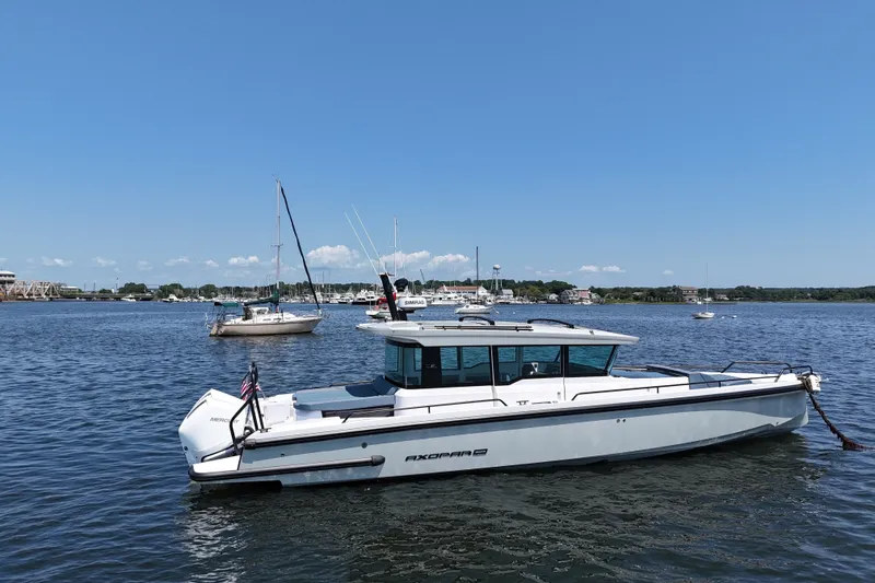 Slide: The Image of 2026 Axopar 37 XC Cross Cabin boat on a sunny day in a calm harbor. - 7