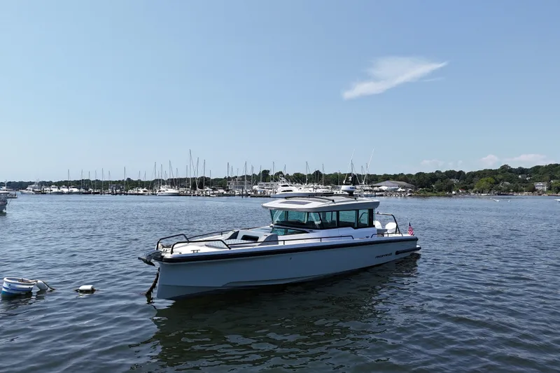 Slide: The Image of 2026 Axopar 37 XC Cross Cabin boat docked in a scenic marina. - 4