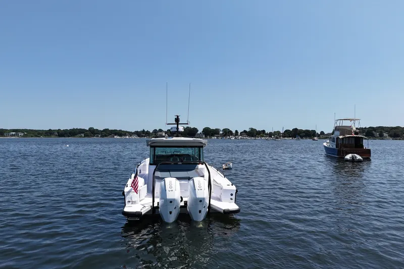 Slide: The Image of 2026 Axopar 37 XC Cross Cabin boat on calm water, rear view. - 5
