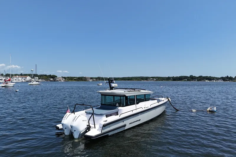 Slide: The Image of 2026 Axopar 37 XC Cross Cabin boat on calm water, clear sky background. - 6