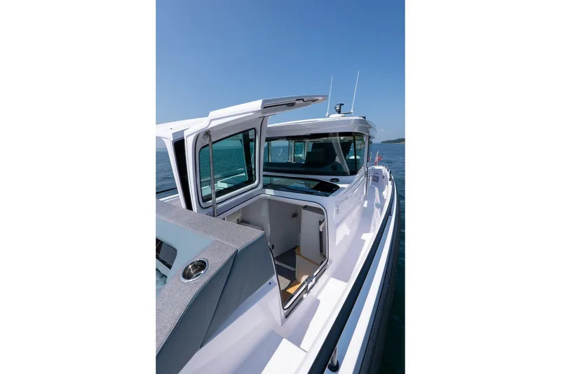 Slide: The Image of Axopar 37 Aft Cabin 2026 with open storage hatch by the water. - 24