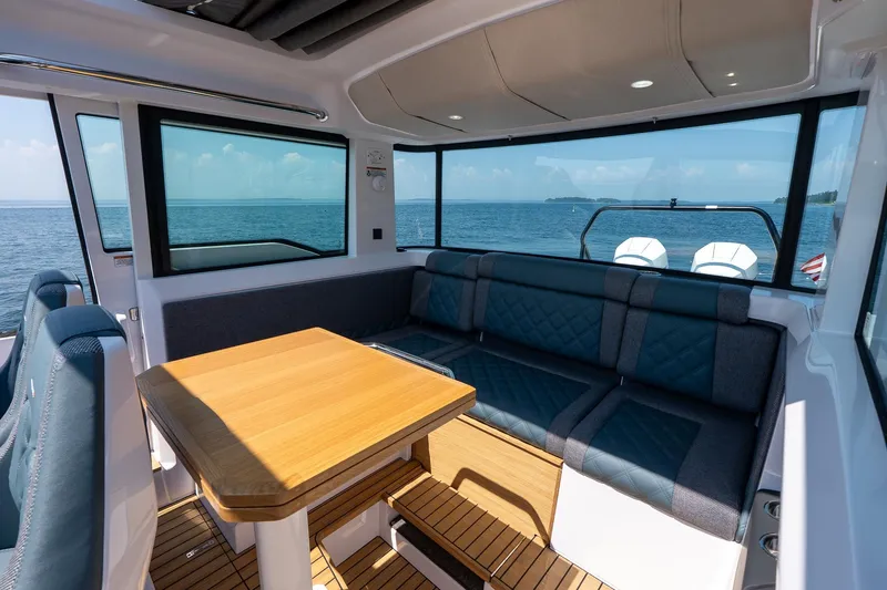 Slide: The Image of 2026 Axopar 37 Aft Cabin on calm waters near wooded shoreline. - 32