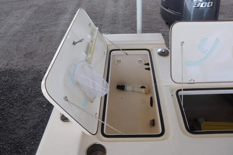 Slide: The Image of Open storage compartments on a 2013 Young Boats 24, featuring a Yamaha 300 engine. - 11