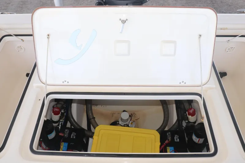 Slide: The Image of Open hatch of a 2013 Young Boats 24, revealing internal components and storage. - 16