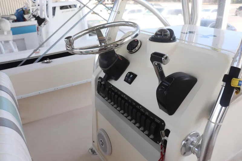 Slide: The Image of 2013 Young Boats 24 helm with steering wheel, controls, and switches. - 22