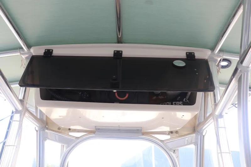 Slide: The Image of 2013 Young Boats 24 console storage with open black panel under canopy. - 23