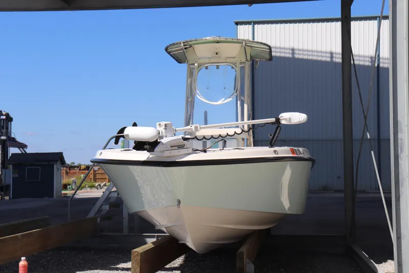 Slide: The Image of 2013 Young Boats 24 model, docked under a shelter, featuring a sleek design. - 3