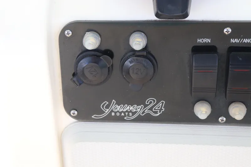 Slide: The Image of Control panel of 2013 Young Boats 24 with 12V outlets and switches. - 33