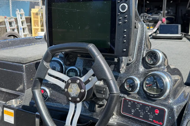 Slide: The Image of 2017 Bass Cat Eyra boat dashboard with steering wheel and electronic display. - 11