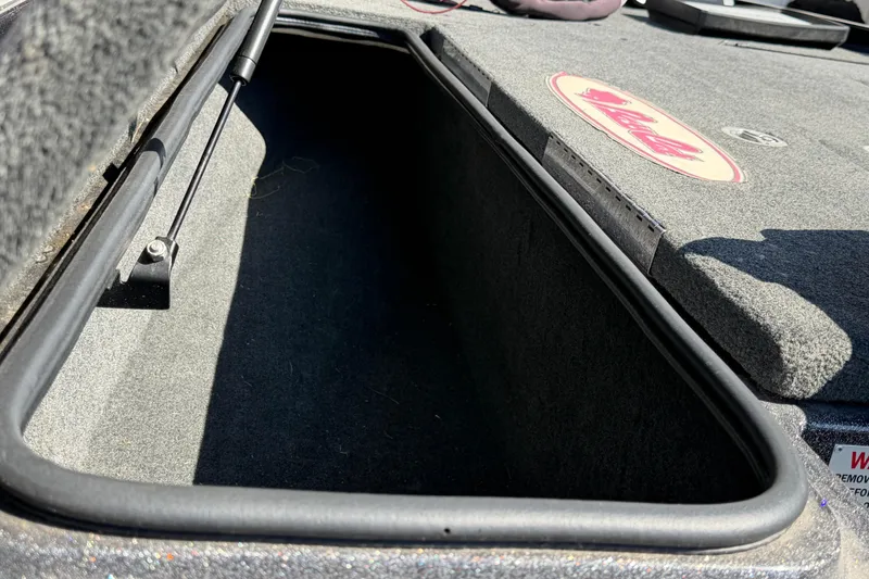 Slide: The Image of Open storage compartment in 2017 Bass Cat Eyra boat, featuring carpeted interior and hydraulic lift. - 19