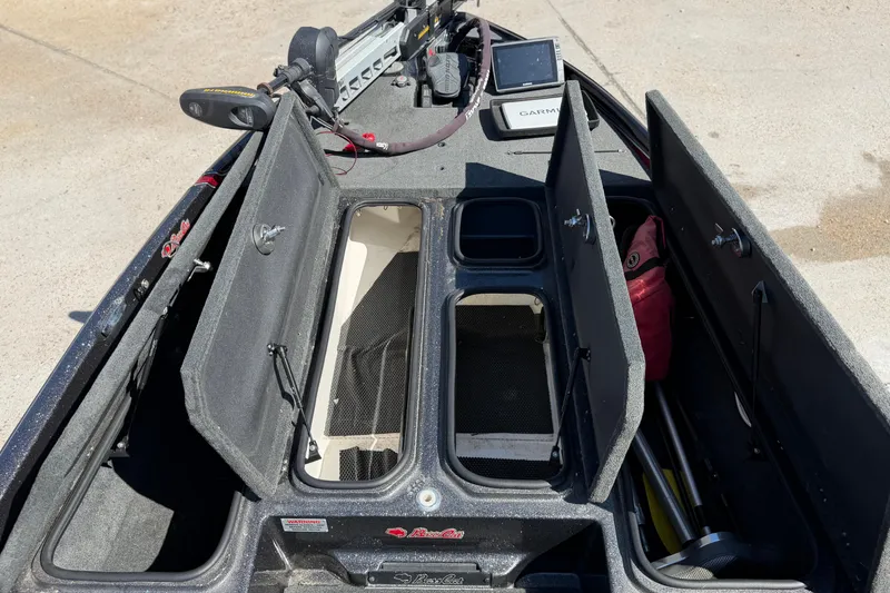 Slide: The Image of 2017 Bass Cat Eyra boat interior with open storage compartments and Garmin device. - 20