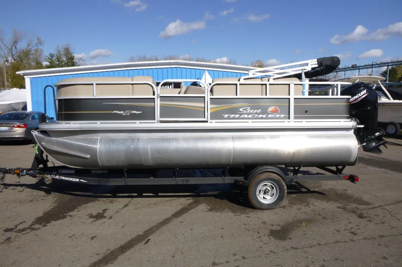 The Image of 2022 Sun Tracker Party Barge 18 DLX pontoon boat on trailer, parked outdoors. - 1