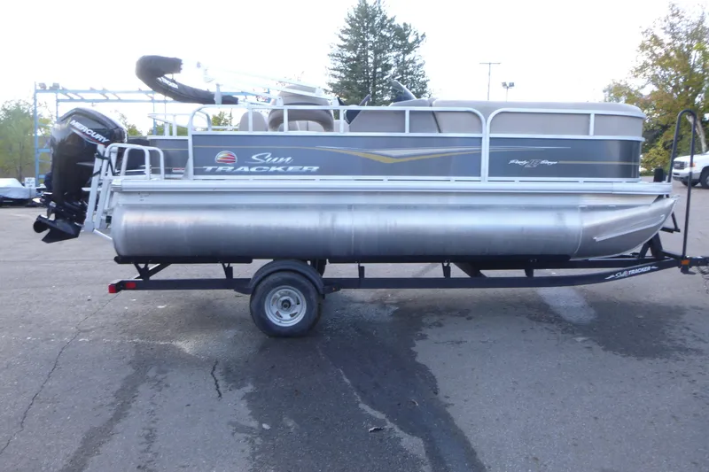 Slide: The Image of 2022 Sun Tracker Party Barge 18 DLX pontoon boat on trailer in parking lot. - 4