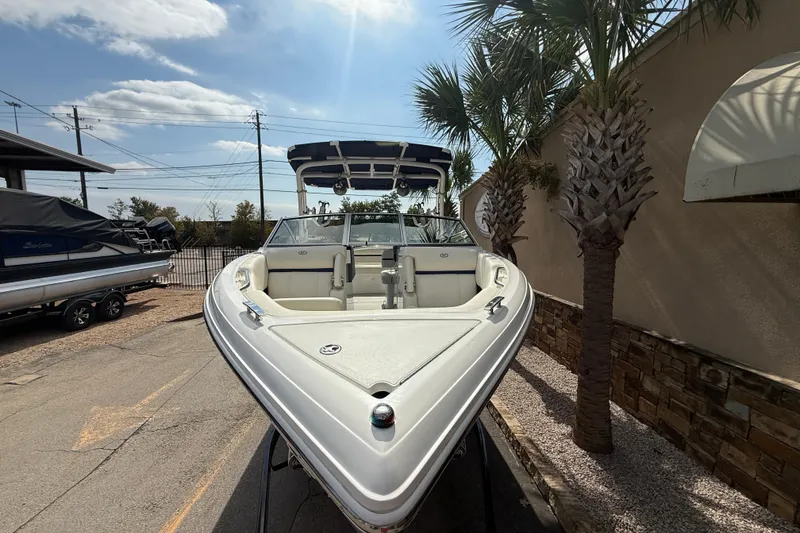 Slide: The Image of 2020 Cobalt R5 Surf boat parked near palm trees under a sunny sky. - 3