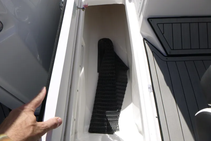 Slide: The Image of Storage compartment in 2026 Yamaha Boats 252SD, featuring a black mat and sleek design. - 13