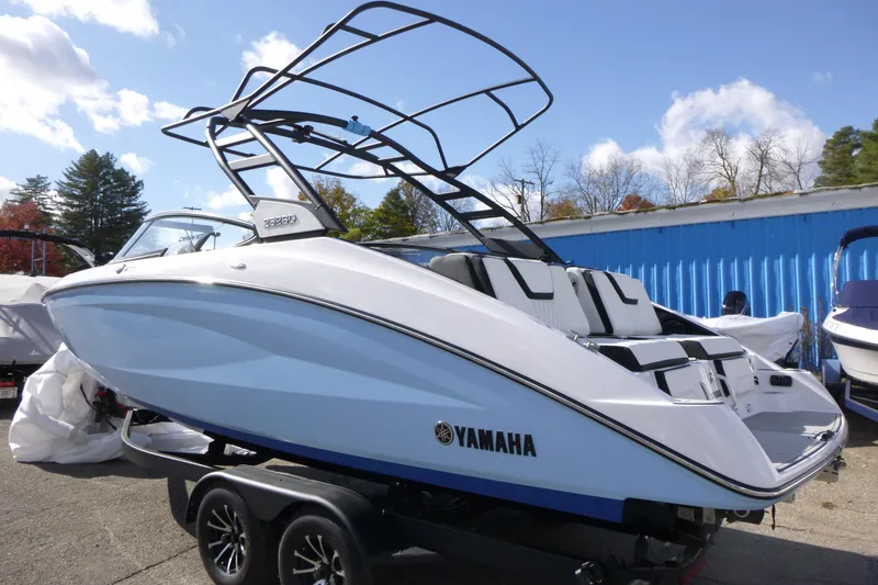 Slide: The Image of 2026 Yamaha Boats 252SD on trailer, sleek design, blue and white exterior, sunny day. - 4