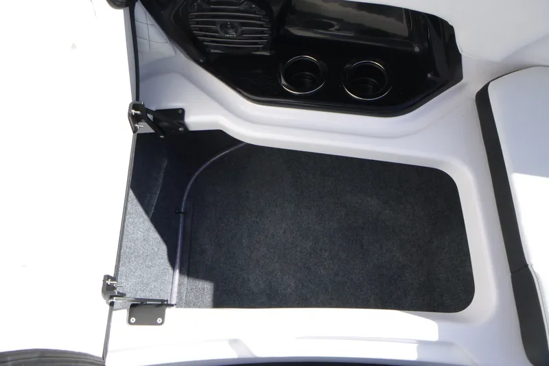 Slide: The Image of 2026 Yamaha Boats 252SD interior storage compartment with cup holders and carpeted flooring. - 8