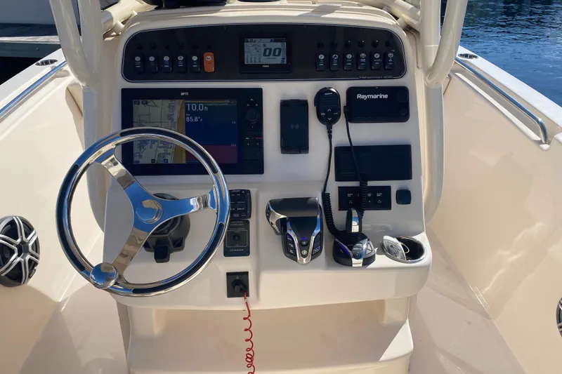 Slide: The Image of 2024 Grady-White Fisherman 236 boat dashboard with steering wheel and navigation controls. - 10