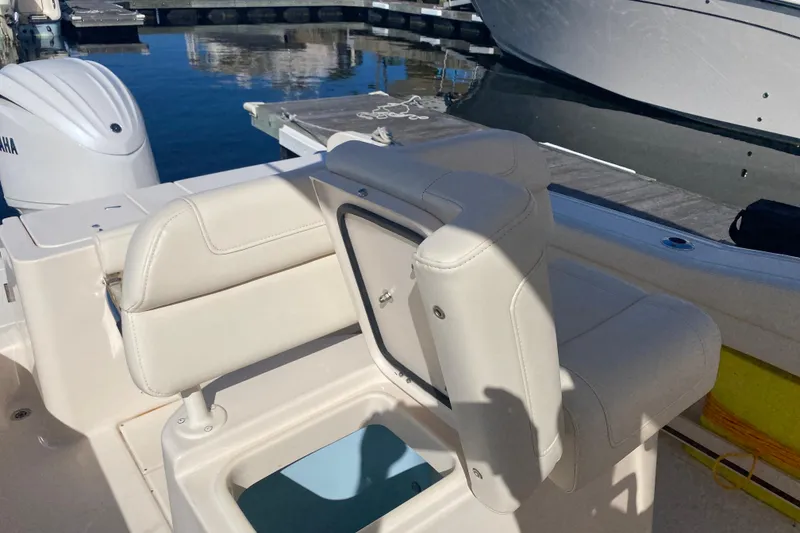 Slide: The Image of 2024 Grady-White Fisherman 236 boat interior with seating and storage, docked by the water. - 13
